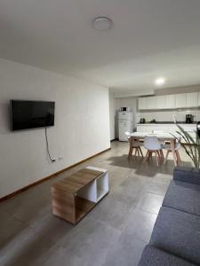 图努扬Departamento 2 habitaciones planta baja Hasta 4 huéspedes的客厅配有沙发和桌子