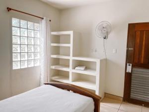 托拉Mar Adentro Sanctuary的卧室配有白色的架子、一张床和风扇
