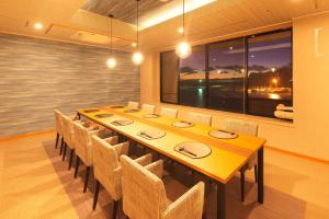 鸭川市基赤木日式旅馆的一间带长桌和椅子的用餐室