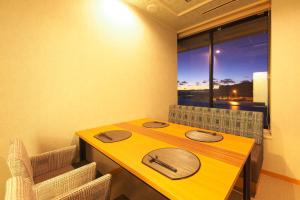 鸭川市基赤木日式旅馆的窗户房间里一张黄色的桌子和椅子
