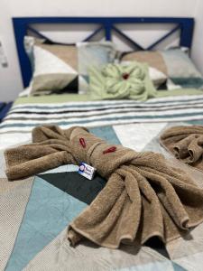 博卡斯德尔托罗Hostal Camping La Y Griega的铺在床上的棕色毛巾