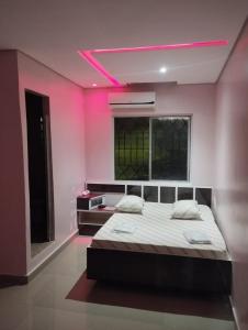 圣贝尔纳多-杜坎普Hotel Simba的一间卧室配有一张带粉红色照明的大床