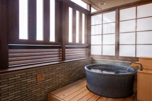 琴平町Onyado Shikishima-kan的带窗户的客房内的大浴缸