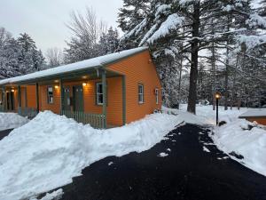 巴特利特The Inn & More的雪中的一个橙色小屋,周围积雪环绕