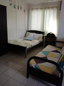 圣罗莎Spacious Studio unit beside Enchanted Kingdom at Santa Rosa City Laguna的一间卧室配有一张床、一张床和一个窗户。