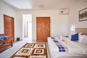南威Malika Nungwi Hotel的一间卧室设有一张大床和一扇木门