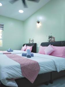 瓜埠Octopus House Langkawi Easy Shop Easy Play的粉红色和白色的客房内的两张床
