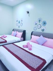 瓜埠Octopus House Langkawi Easy Shop Easy Play的客房内的两张床和粉红色枕头