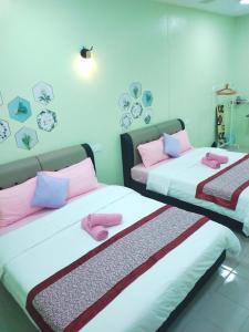 瓜埠Octopus House Langkawi Easy Shop Easy Play的配有粉红色和紫色枕头的客房内的两张床