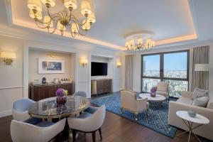 安曼The Ritz-Carlton, Amman的一间带桌椅的客厅和一间客厅。