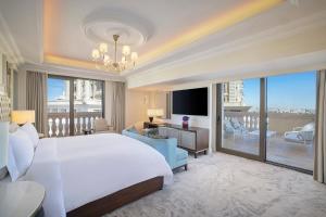 安曼The Ritz-Carlton, Amman的一间带一张白色大床的卧室和一个阳台