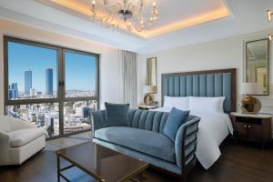 安曼The Ritz-Carlton, Amman的一间卧室配有一张床、一张沙发和一个窗口