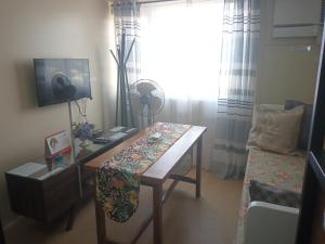 达沃市NICE CORNER AYALA 1 bedroom condo at heart of DAVAO CITY with hi speed wi fi internet的客厅配有桌子和窗户