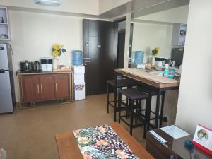 达沃市NICE CORNER AYALA 1 bedroom condo at heart of DAVAO CITY with hi speed wi fi internet的厨房配有柜台、桌子和台面