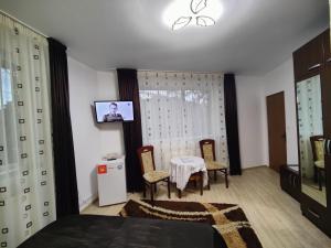 锡纳亚Casa Adina的一间卧室配有桌椅和电视。