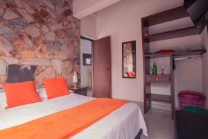 麦德林Hotel Palma De Sevilla的一间卧室设有一张床和石墙
