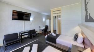 贝纳拉玫瑰城汽车旅馆 的酒店客房,配有一张床、一张桌子和椅子