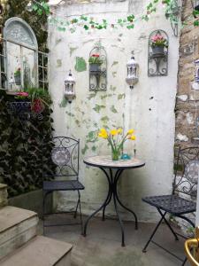 斯基普顿Little Pinfold Cottage的一张桌子,上面有两把椅子和花瓶