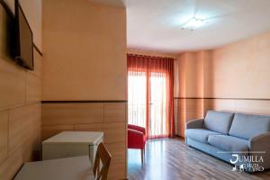胡米利亚皮奥十二乔米拉酒店的客厅配有蓝色的沙发和桌子