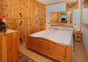 萨奥兹-杜尔克斯Salone House的一间带木墙的卧室和一张位于客房内的床