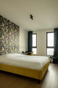 安特卫普UNIEK appartement - mooiste en hoogste uitzicht op Antwerpen! - incl gratis parking的一间卧室配有一张带花卉壁纸的大床