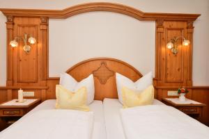 苏尔茨贝格Hotel-Pension Seebad "Seegenuss-Natur-Spa"的一间卧室配有两张带白色床单和黄色枕头的床。