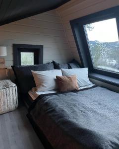 克拉格勒Mikrohyttene Moen Ranch的卧室配有带枕头的床铺和窗户。