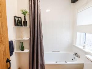 莱普斯通The Pepper Pot的白色的浴室设有浴缸和窗户。