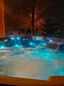 SąpówLendHouse - SPA pod Gwiazdami的游泳池在晚上有蓝色的灯光
