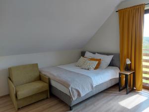 瓦多维采Barwald Hills的卧室配有床、椅子和窗户。