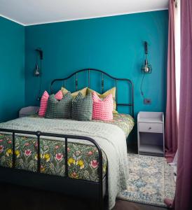 约纳瓦Apartment Secret的蓝色卧室配有带色彩缤纷枕头的床