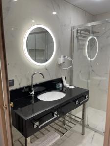 苏呼米Grand Hotel Sukhum Resorts的一间带水槽和镜子的浴室