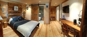 瓦什雷斯Atelier des Sapins Blancs (chambre double)的卧室配有一张床铺,位于带木墙的房间内