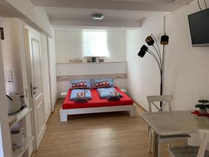耶拿Ferienwohnung "Alte Mühle"的一间卧室配有红色的床和一张桌子