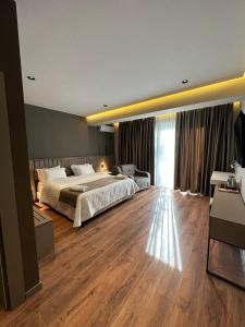Kukës加里卡酒店的一间卧室设有一张大床,铺有木地板