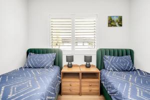 悉尼Spacious 4BR Villa with Office l Modern & Convenient的卧室内两张并排的床