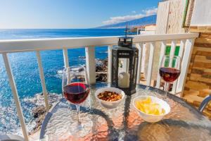 圣克鲁斯-德特内里费Spacious studio next to the sea with stunning views的阳台上的桌子和两杯葡萄酒