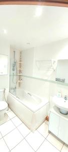 泰晤士河畔金斯顿Cosy 2 bedroom appartment with gated parking by River Thames的带浴缸、卫生间和盥洗盆的浴室
