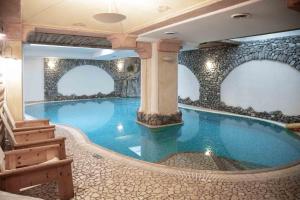 利维尼奥赫尔维蒂酒店的一个带spa的酒店客房内的大型游泳池