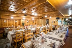 利维尼奥赫尔维蒂酒店的用餐室配有桌椅和白色的桌布