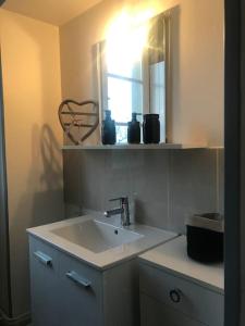 圣梅尔埃格利斯Gîte spacieux et chaleureux的一间带水槽和镜子的浴室