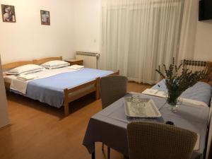 Široki BrijegSobe Pipić的一间卧室配有两张床和一张桌椅