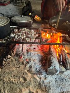 木州县Hoa Phong homestay Moc Chau的火烤架上烹饪食物的人