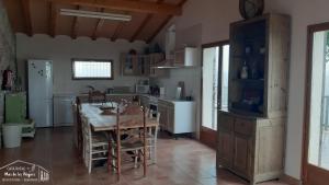 梅基嫩萨Casa Rural Mas de les Àligues的一间带木桌的厨房和一间餐厅