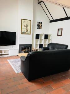 科克赛德Vissershuisje 6 te Koksijde的客厅配有黑色沙发和平面电视。
