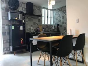 彼得罗波利斯Apartamentos Aconchegantes Bingen em Petrópolis的厨房配有桌椅和冰箱。