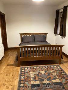 阿马Ridge Wood House的一间卧室配有一张带地毯的木床