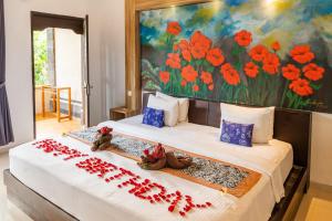 乌布Dewangga Ubud的一间卧室配有两张红色鲜花的床