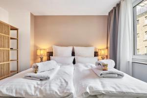 科隆Park Avenue - Design Apartment Friesenstraße - 4 Pers - WLAN - Netflix - 65 Zoll TV的卧室配有一张带白色床单和毛巾的大床。