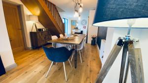 圣艾夫斯Tregenna House - St Ives, A Beautiful Newly Refurbished 4 Bedroom Family Town House With Alfresco Dining Garden and Private Parking Spaces的一间带桌子和蓝椅的用餐室
